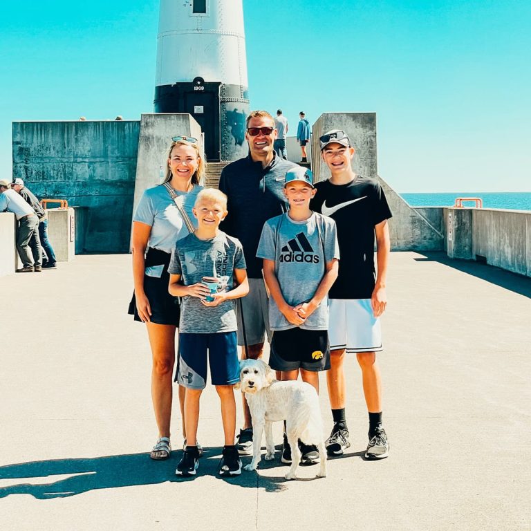 Jen and family standing in front of lighthouse.