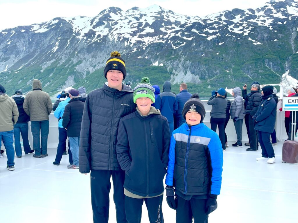 3 boys standing in front of mountains